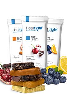 Three "Heal Right" micronutrient bars in their wrappers and surrounded by blocks of chocolate, blueberries and raspsberries