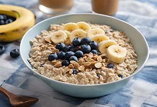 A bowl of oatmeal topped with blueberries and sliced banana.