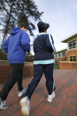 Exercise A man and a woman in athletic clothing taking a fast-paced walk