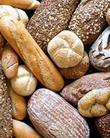 Many mixed breads and rolls shot from above.