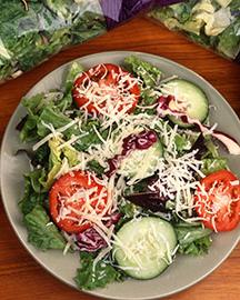 A sald of lettuce, tomatoes, cucumbers and cheese