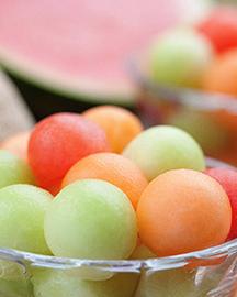 A bowl of honeydew, cantaloupe and watermelon balls. 