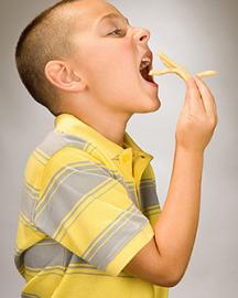 A boy eating French fries