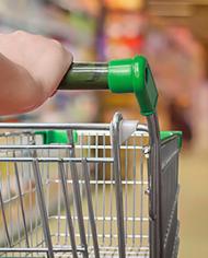 A green handled shopping cart being pushed down an aisle. Links to the Science in Your Shopping Cart section.  