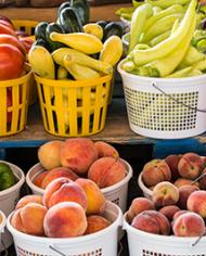 Baskets of tomatoes, pepers, peaches and squash