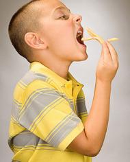 A boy eating French fries