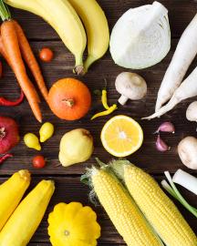White, yellow, green, orange, red, purple fruits and vegetables on wooden background. 