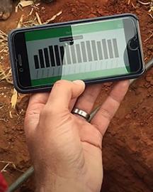 A hand holding a mobile phone displaying an app